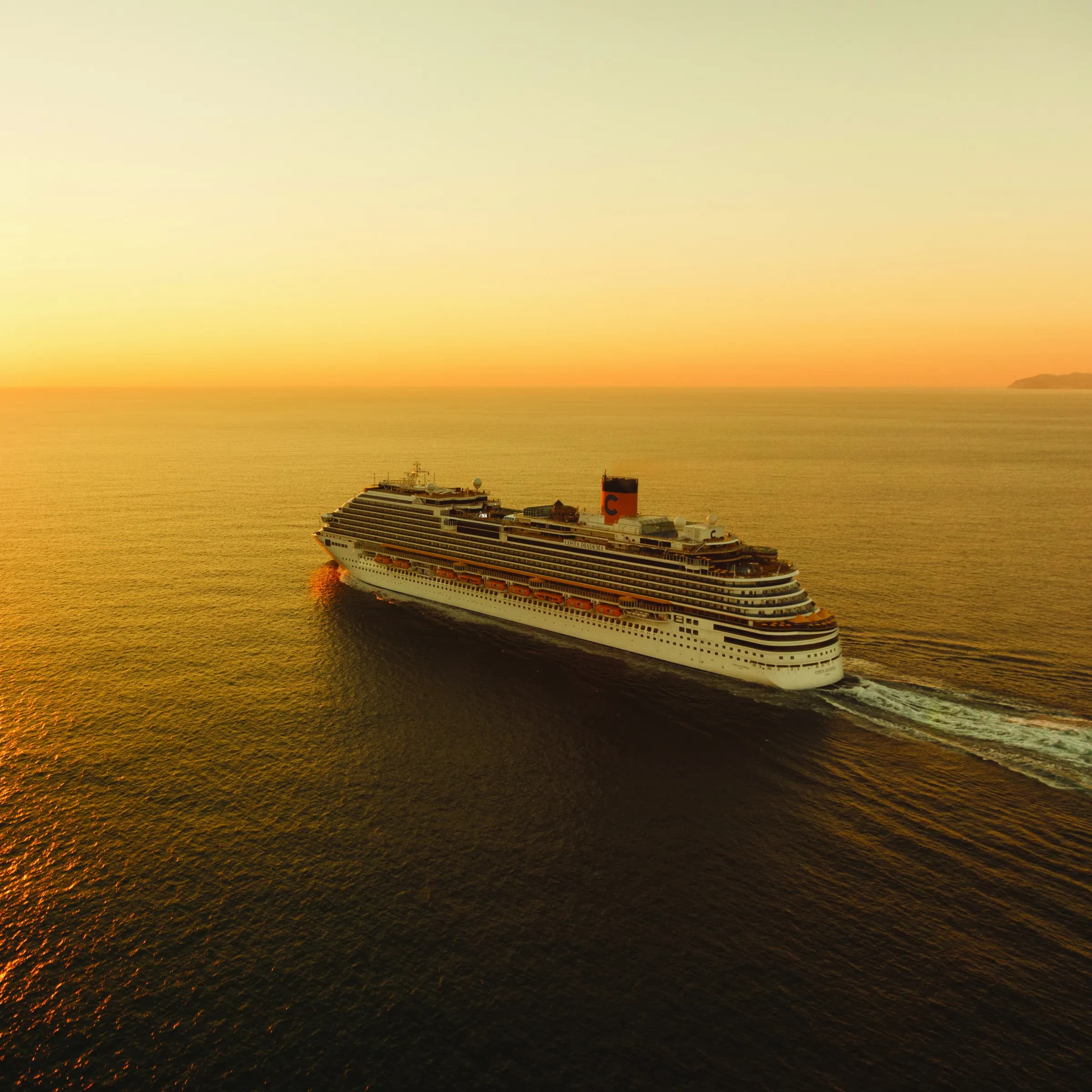 Costa Kreuzfahrtschiff bei warmem Sonnenuntergang auf See