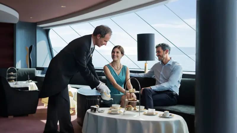 MSC Magnifica: Kellner serviert Gästen Tee in einer Lounge mit Meerblick