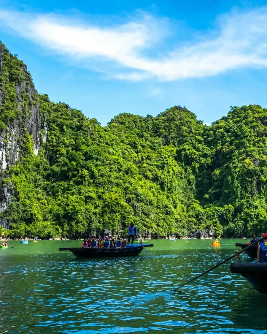 Ausflugsboote mit Reisenden zwischen den Kalkfelsen der Halong-Bucht