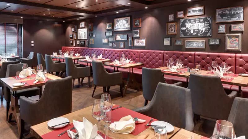 MSC Bellissima: Restaurant mit roten Sitzbänken und Bilderwand