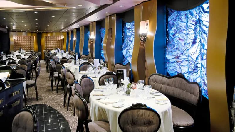 MSC Divina: Restaurant mit festlich gedeckten Tischen und leuchtenden Glaswänden