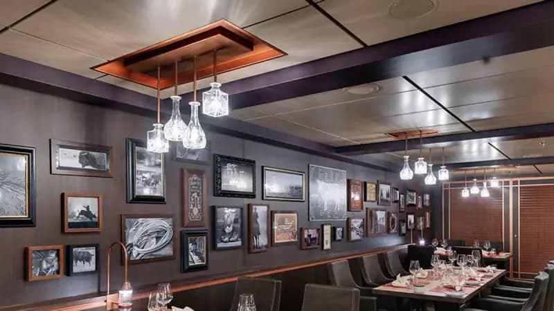 MSC Grandiosa: Restaurant mit Bilderwand und gedeckten Tischen