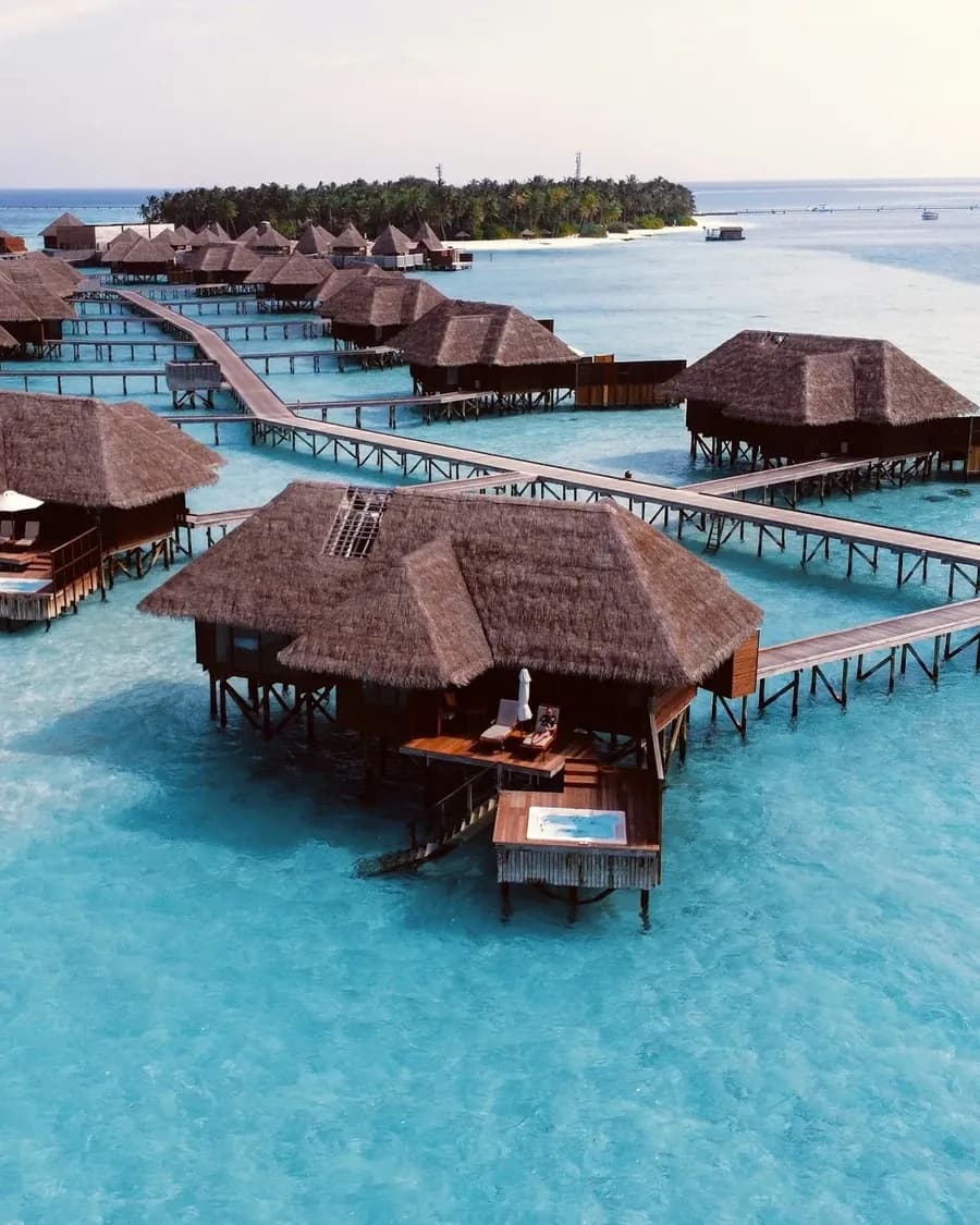Überwasserbungalows über türkisem Wasser auf den Malediven