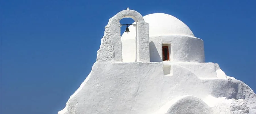 Windmühlen und weiße Häuser an der Küste von Mykonos