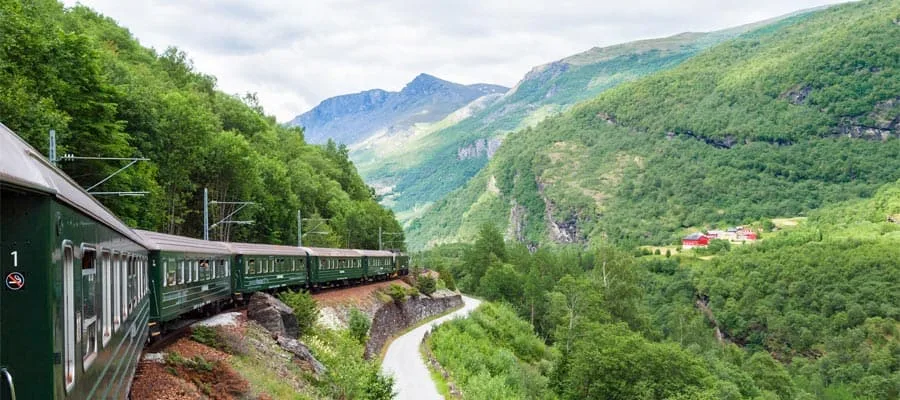 Schmales Dorf am Fjordufer zwischen hohen Bergen bei Flåm